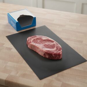 Black Steak Paper 10" x 30" shown with steak on sheet