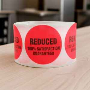 reduced sticker on a round red label with black print with 100% satisfaction guaranteed