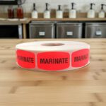 marinate stickers on a roll of red labels with black print