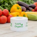100% organic label on a round white sticker with green print and a leaf above the I