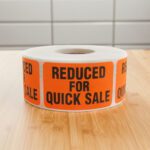 reduced for quick sale sticker on an orange rectangle label with black print