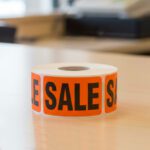 sale sticker on an orange rectangle label with black print