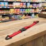 Replacement black shopping cart seat belt with break-resistant buckle shown laid out