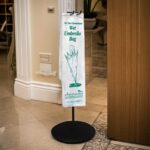 Biodegradable wet umbrella bag on a rack in a hotel lobby