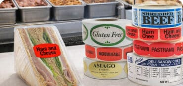 Deli labels on Deli counter top with ham and cheese label on sandwich