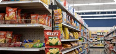 merchandising strip holding bags of crackers on retail shelving