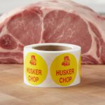 Husker chop sticker on a yellow label with cartoon image of husker