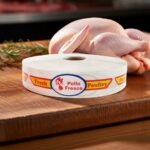 fresh poultry bilingual spanish and english strap label on roll of sticker on butcher block