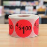 4 for 1 dollar round sticker on a red label with black text