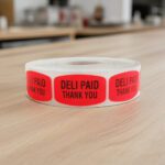 deli paid thank you sticker on a red label with black print