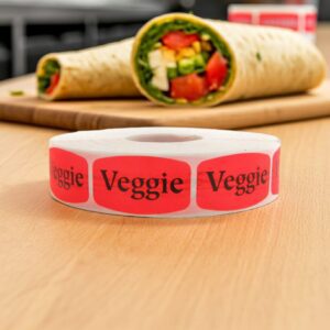 Veggie sticker red identification label with black print on a roll of stickers
