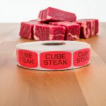 cube steak sticker on a red label with black print
