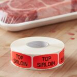 Top Sirloin Butcher sticker red identification label with black print on a roll of stickers