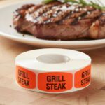 grill steak sticker on a red label with black print
