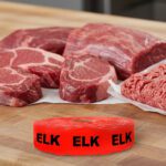 elk sticker on a red label with black print