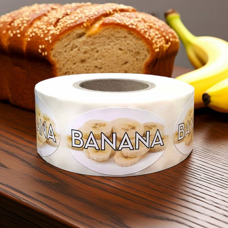 560082 Banana-Label-Bakery-Flavor-Stickers-500_1 banana label showing slices of bananas in the background on a roll of stickers