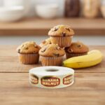 banana walnut gold foil sticker on a rectangle label in front of banana walnut muffins