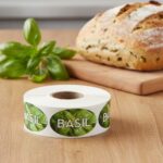 basil label with green leaf basil in the background and the word basil on the front on a roll of stickers