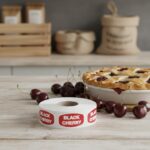 black cherry label on a roll of stickers next to a cherry pie